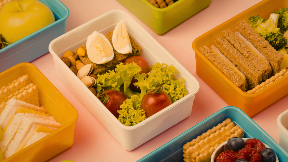 Colorful packed lunchboxes with sandwiches, eggs, fruit, and vegetables for school lunch ideas for kids