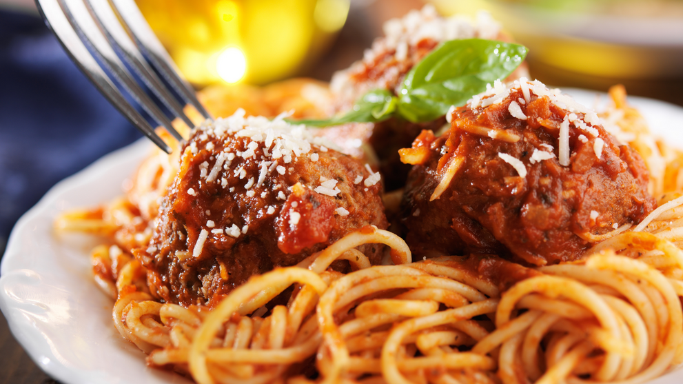 Plate of spaghetti and meatballs topped with parmesan and fresh basil, a school lunch idea for picky eaters