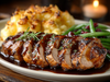 Sliced roasted pork with gravy on a plate with mashed potatoes and green beans.