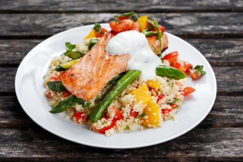 This mediterranean inspired salmon dish is a healthy, fresh delicious recipe. Our salmon is seasoned and grilled to perfection and served with vegetables, gold and red bell pepper, and healthy lemony quinoa over a bed of spinach served with Tzatziki sauce