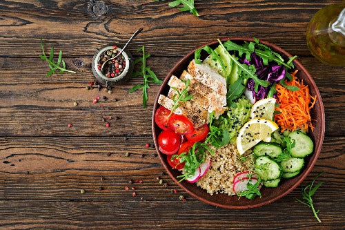 Buddha Chicken Bowl with Peppercorn Ranch - Low Carb. Tender Grilled Chicken is sliced and served with organic spring greens, shredded carrots, arugula, cherry tomatoes, red quinoa, cucumbers, cabbage and a guacamole cup. Served with our homemade peppercorn ranch dressing for you to drizzle as you’d like.
