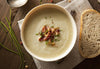 Homemade Potato and Leek Soup. Creamy potatoes are combined with savory roasted garlic and leeks in a hearty chicken stock topped with a side of Bacon.
